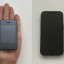 Light Phone II op de hand en naast iPhone 13 Mini