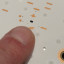 De piepkleine led-driver temidden van de leds (de ronde schijfjes zijn de lenzen, de led is de kleine stip)